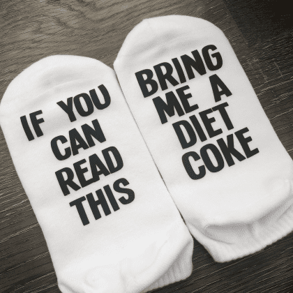 If you can read this bring me a diet coke socks. Black lettering found on the bottom of the sock