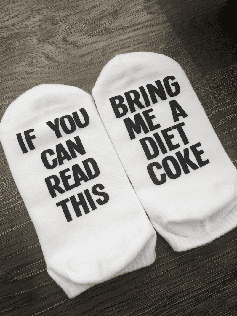 If you can read this bring me a diet coke socks. Black lettering found on the bottom of the sock